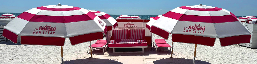 Branded red and white striped beach umbrellas and lounge seating creating a cohesive commercial outdoor setup for resorts, hotels, and beachfront hospitality spaces.